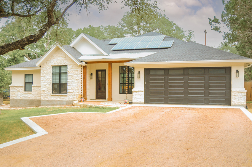 Front view of custom home built in Woodcreek, Texas but S.B. Thompson Construction. Modern farmhouse design. White limestone and stucco with oak beams and grey/black garage door.