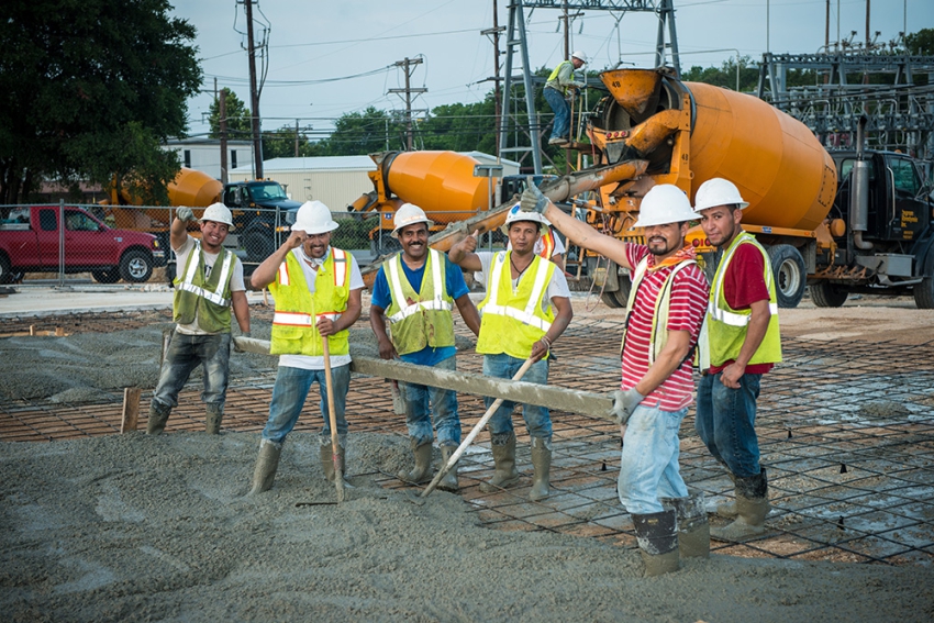 Contractors pouring concrete for large commercial building.